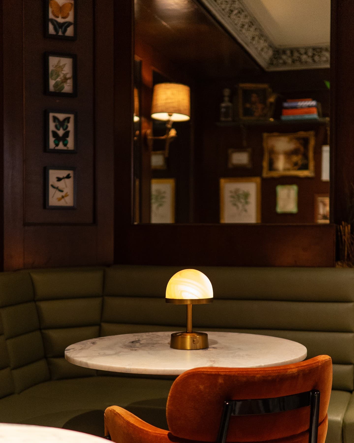 An amber cocktail with an orange coin in low light
